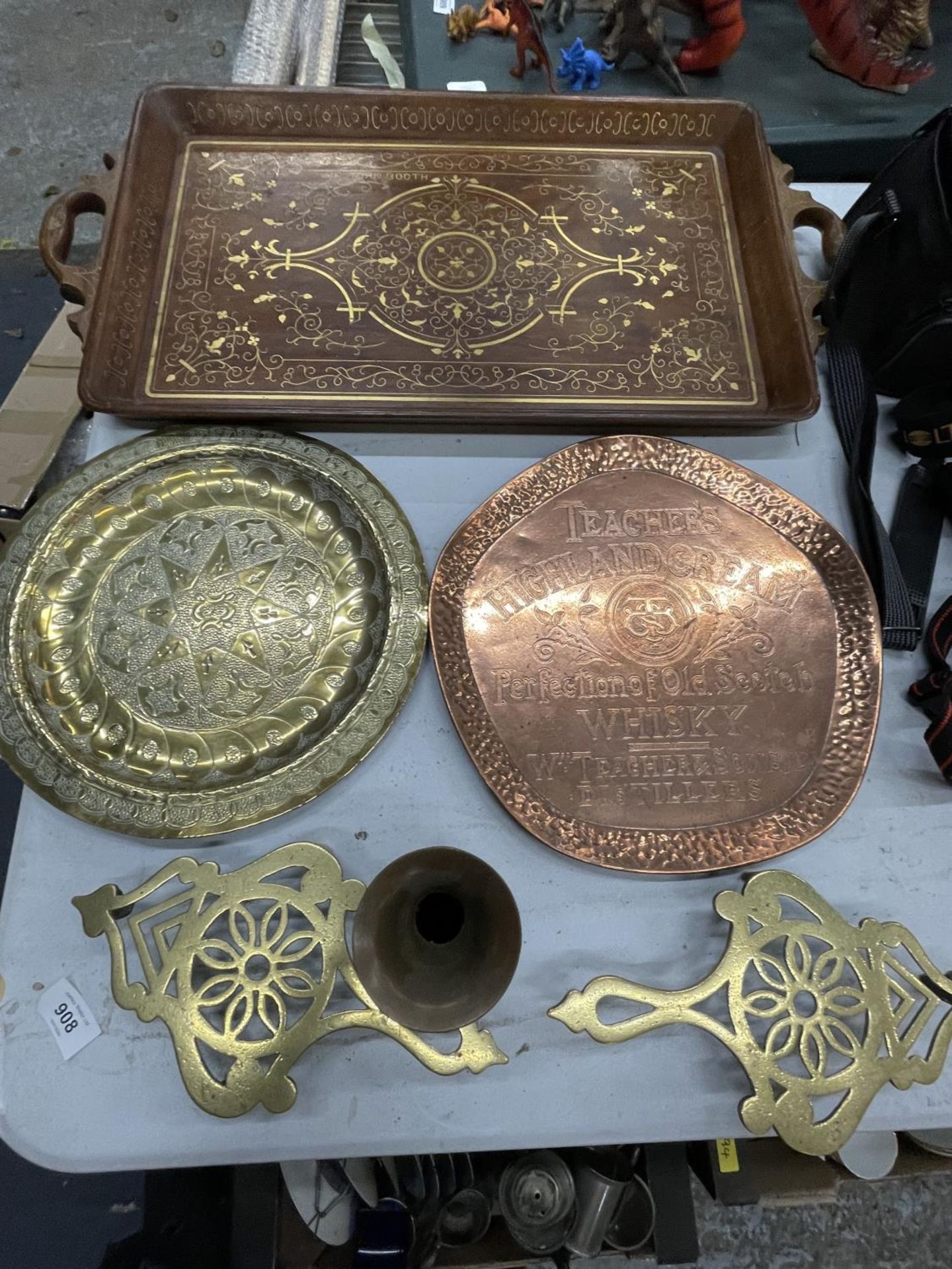 A QUANTITY OF BRASS ITEMS TO INCLUDE A BRASS INLAID WOODEN TRAY, TRIVETS, A WALL PLATE PLUS A COPPER