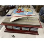 A HAND-PAINTED SCULPTURE OF CONCORDE ON A WOODEN PLINTH WITH MINT CONDITION ROYAL MAIL STAMPS AND