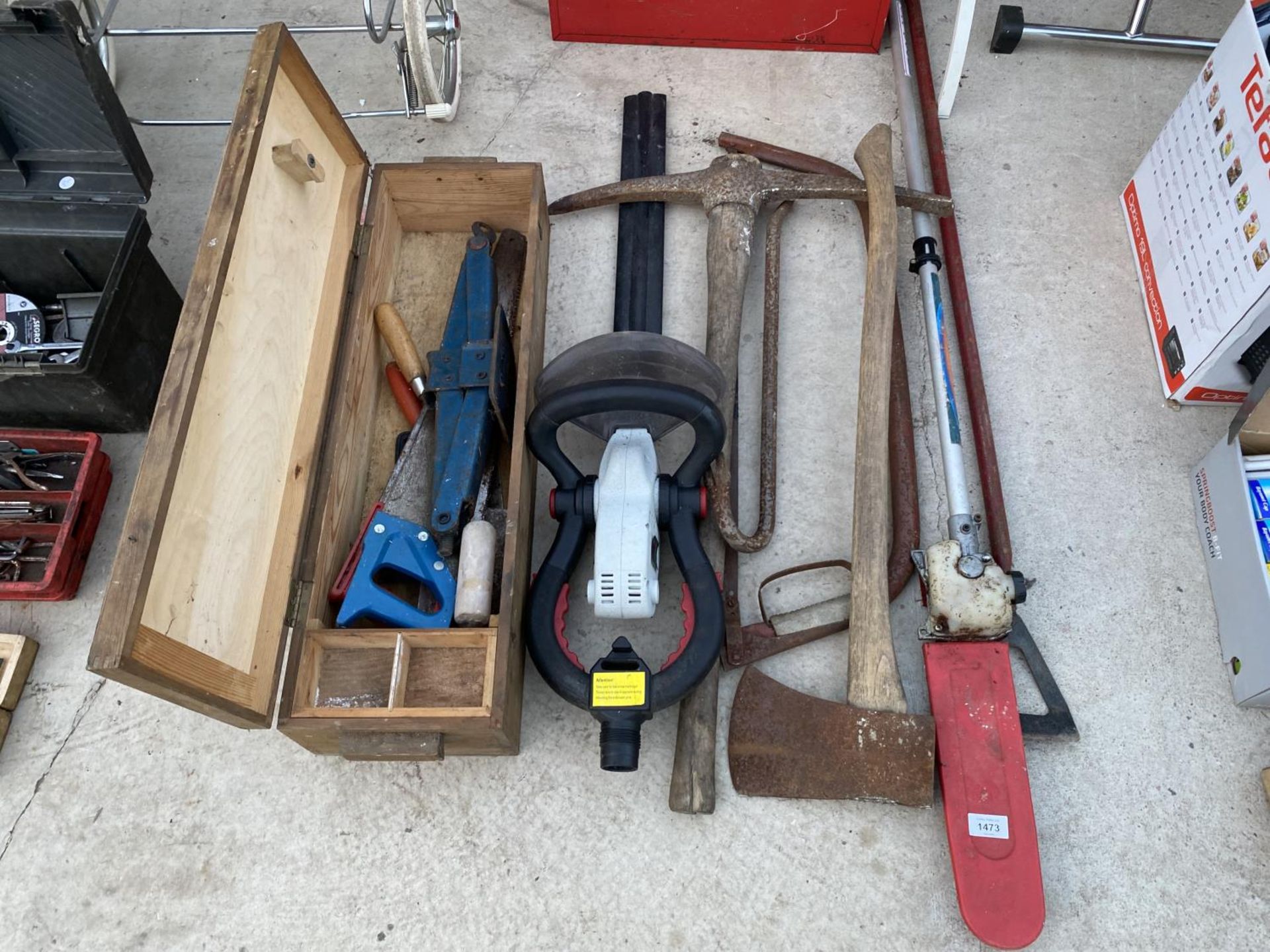 AN ASSORTMENT OF TOOLS TO INCLUDE AN AXE, A PICK AXE AND A CHAINSAW POLE ETC