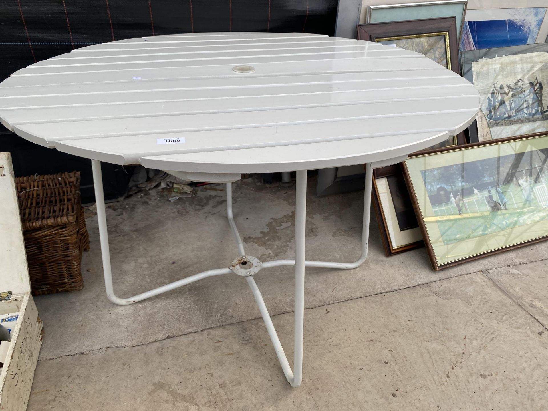 A ROUND WOODEN SLATTED TABLE