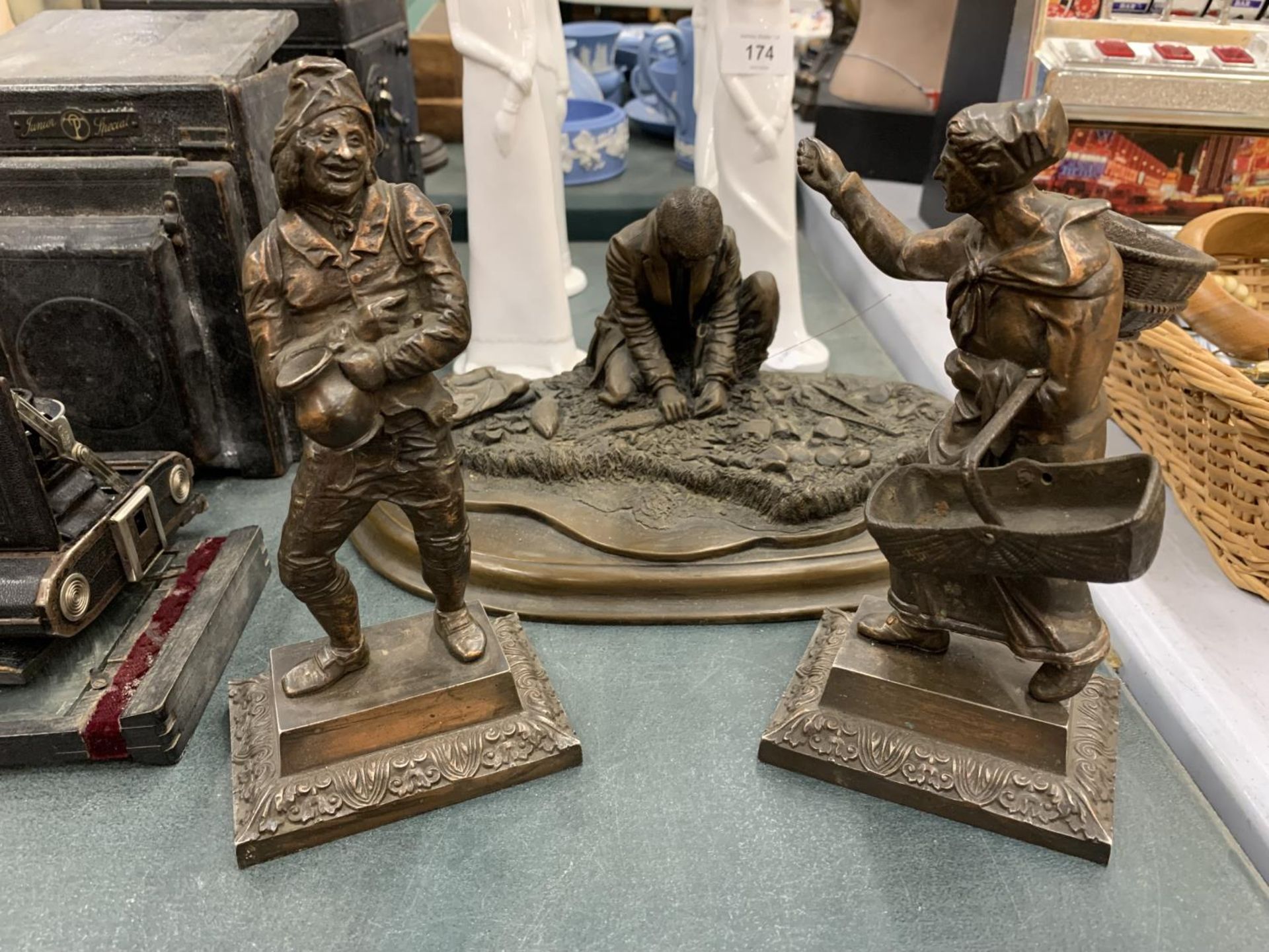 THREE BRONZE STYLE FIGURES TO INCLUDE GRAPE PICKERS AND A FISHERMAN