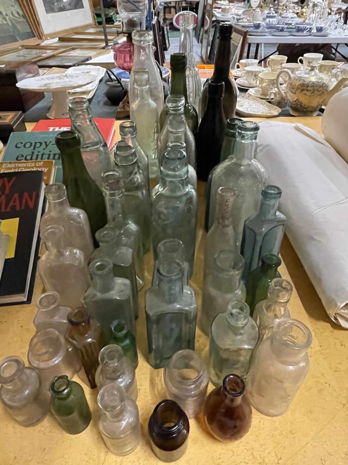 A LARGE QUANTITY OF VINTAGE GLASS BOTTLES TO INCLUDE SOME WITH GLASS MARBLES