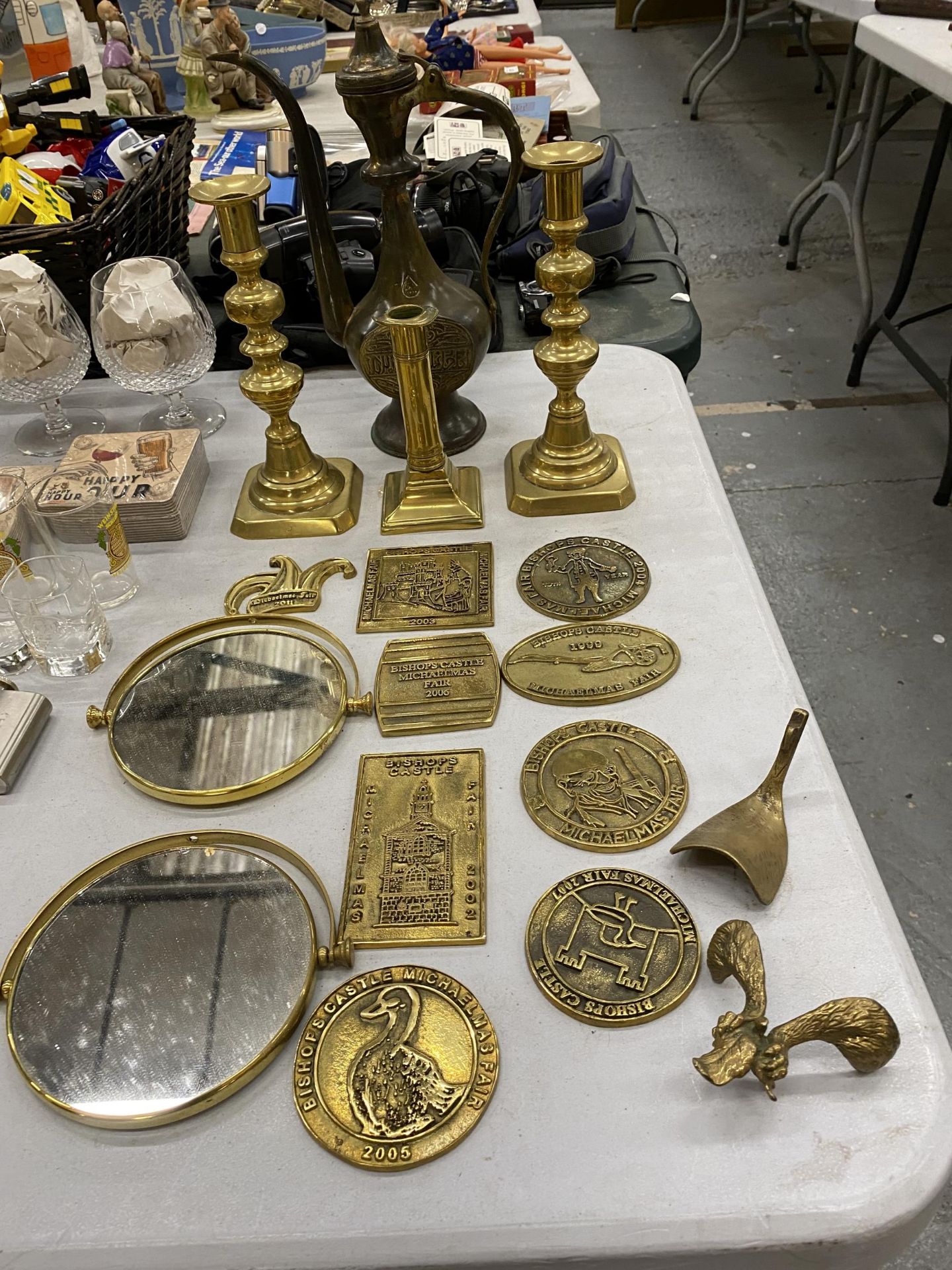 A QUANTITY OF VINTAGE BRASS MICHAELMAS FAIR PLAQUES, CANDLESTICKS AND A MIDDLE EASTERN STYLE
