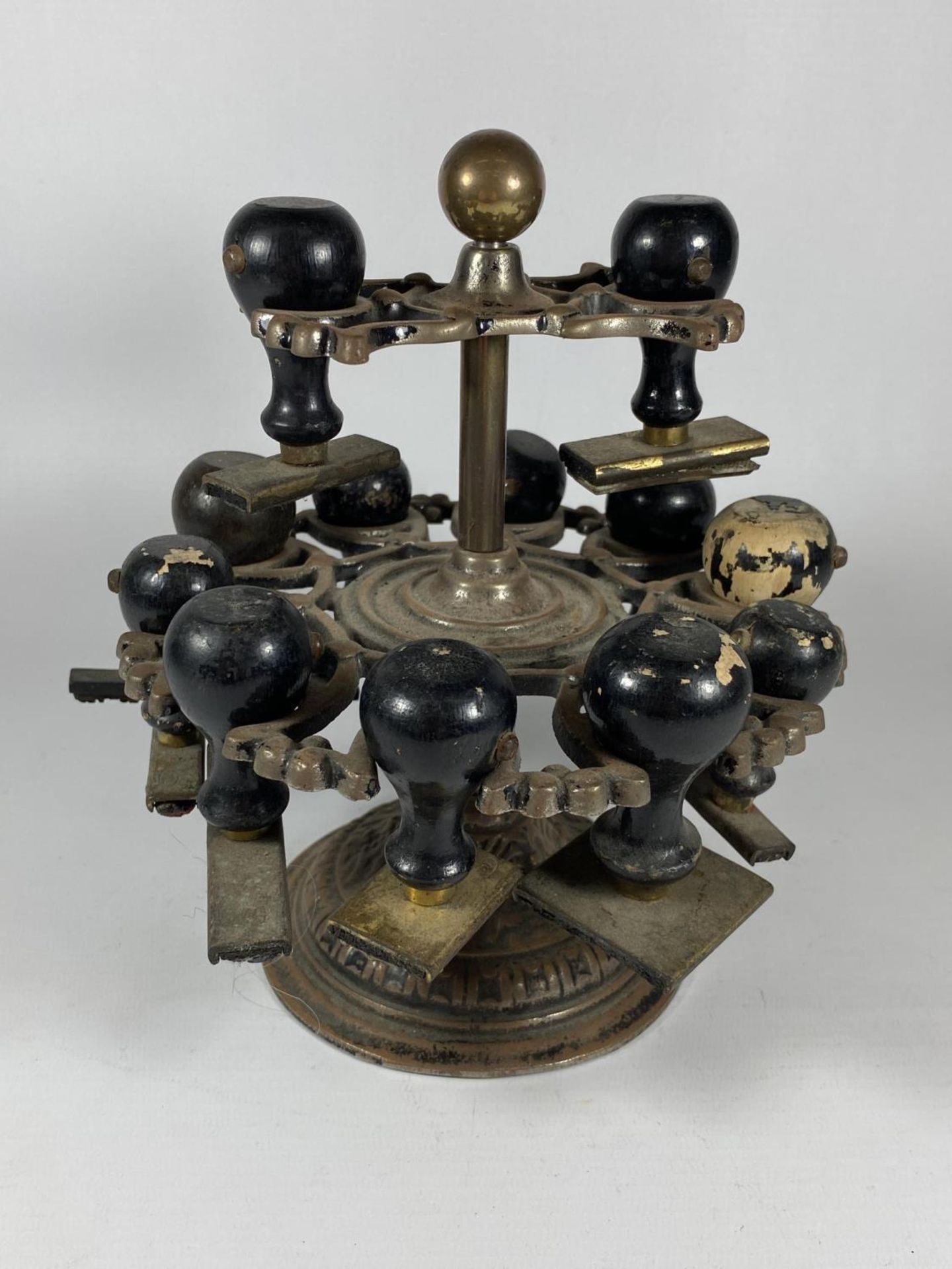AN UNUSUAL 19TH CENTURY BRASS TWO TIER REVOLVING STAMP HOLDER WITH ORIGINAL EBONY HANDLED STAMPS,