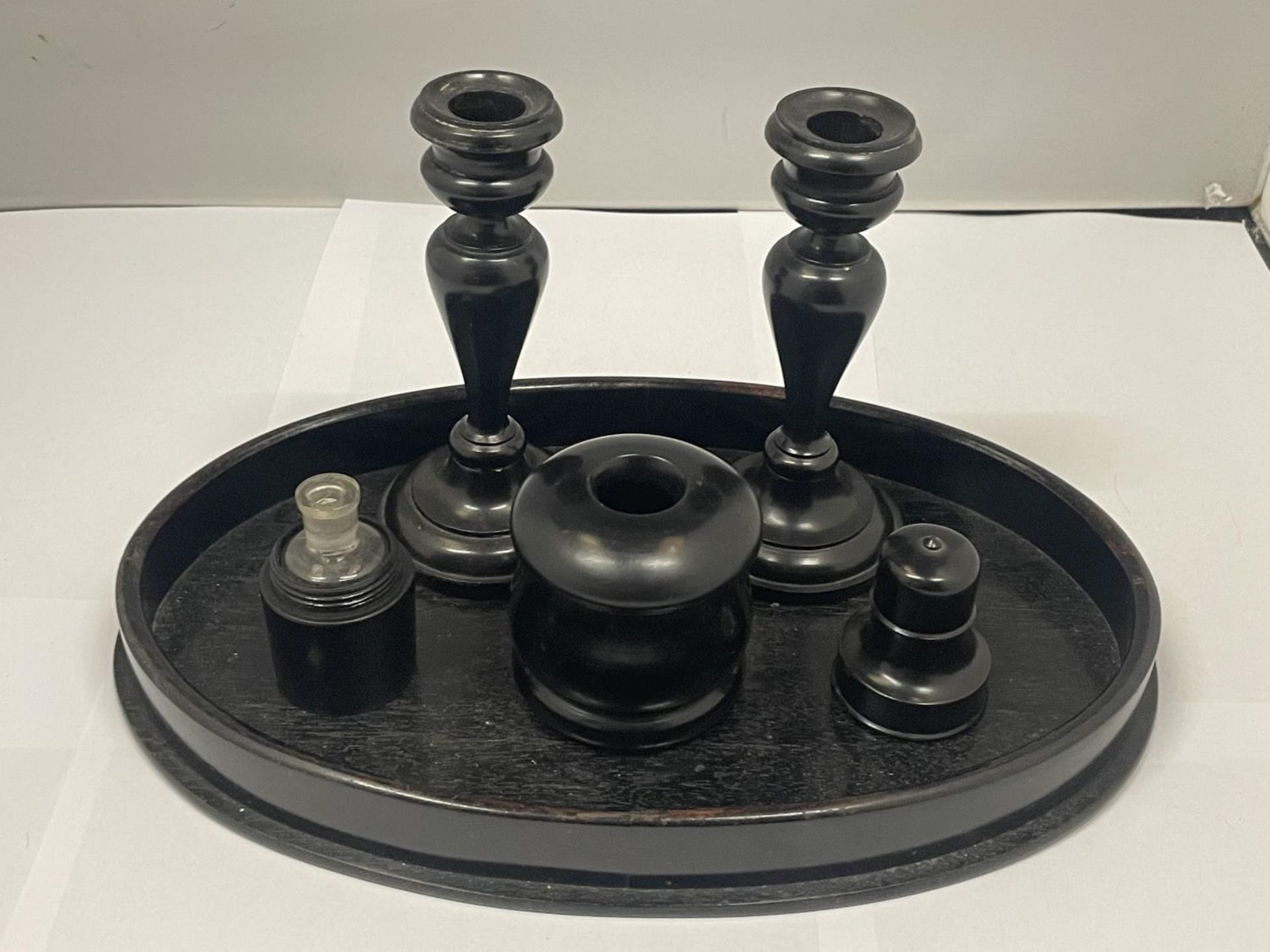 AN EBONY DRESSING TABLE SET TO INCLUDE A TRAY, CANDLESTICKS, PERFUME BOTTLE, ETC