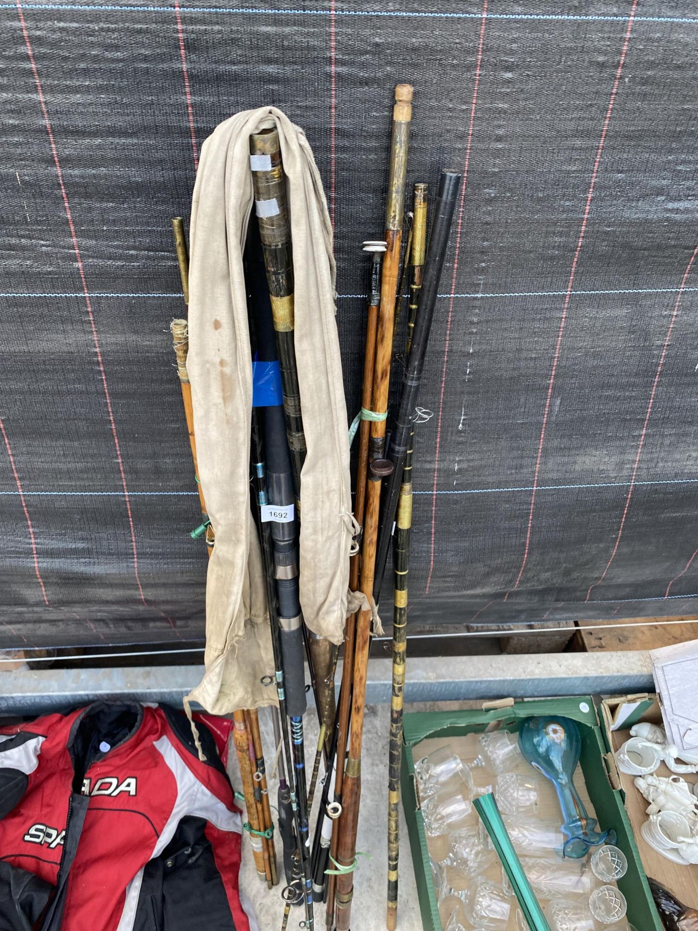 AN ASSORTMENT OF VINTAGE SPLIT CANE FISHING RODS AND MODERN CARBON FIBRE RODS