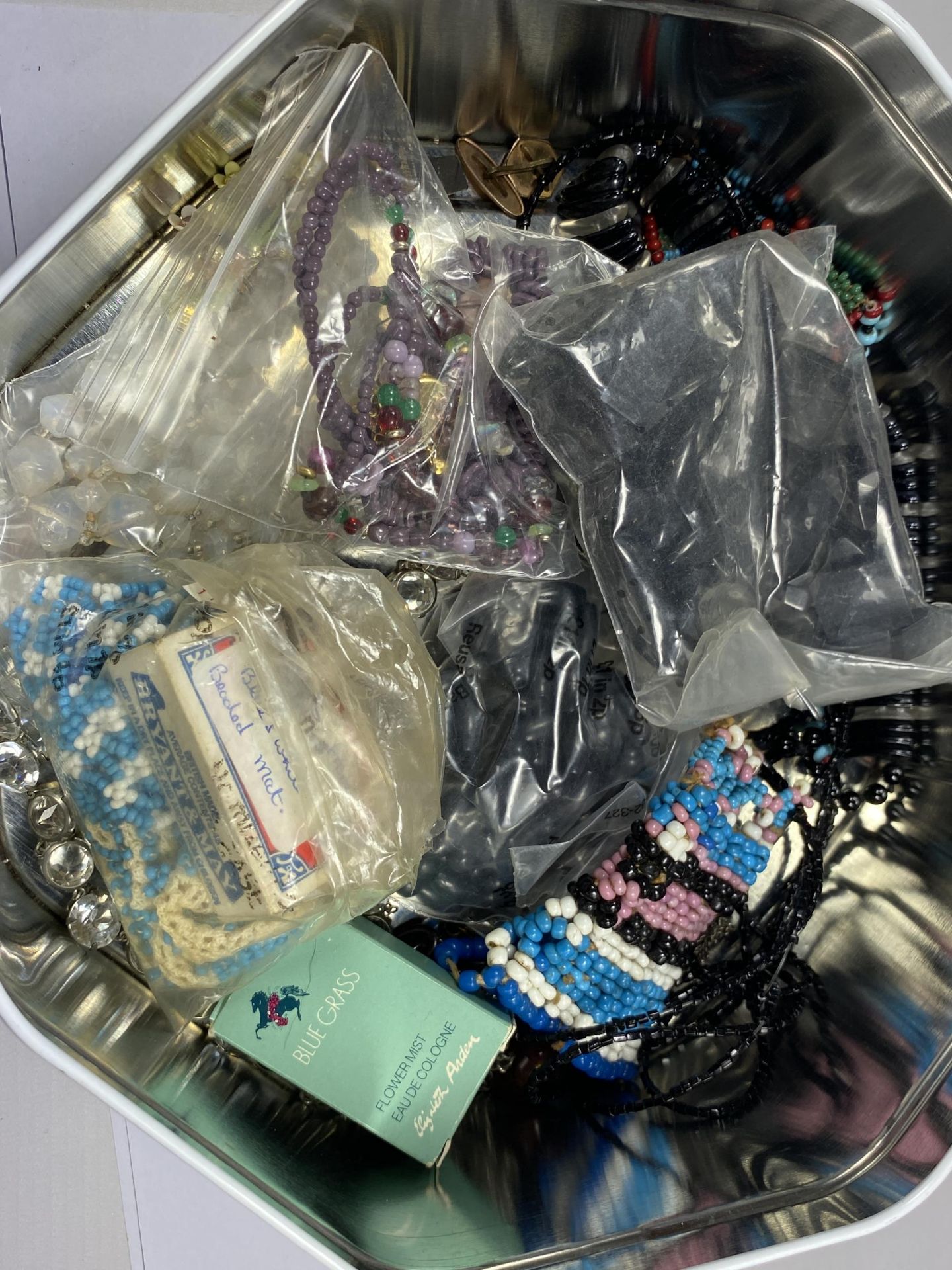 A TIN OF ASSORTED COSTUME JEWELLERY TO INCLUDE BEAD NECKLACES ETC