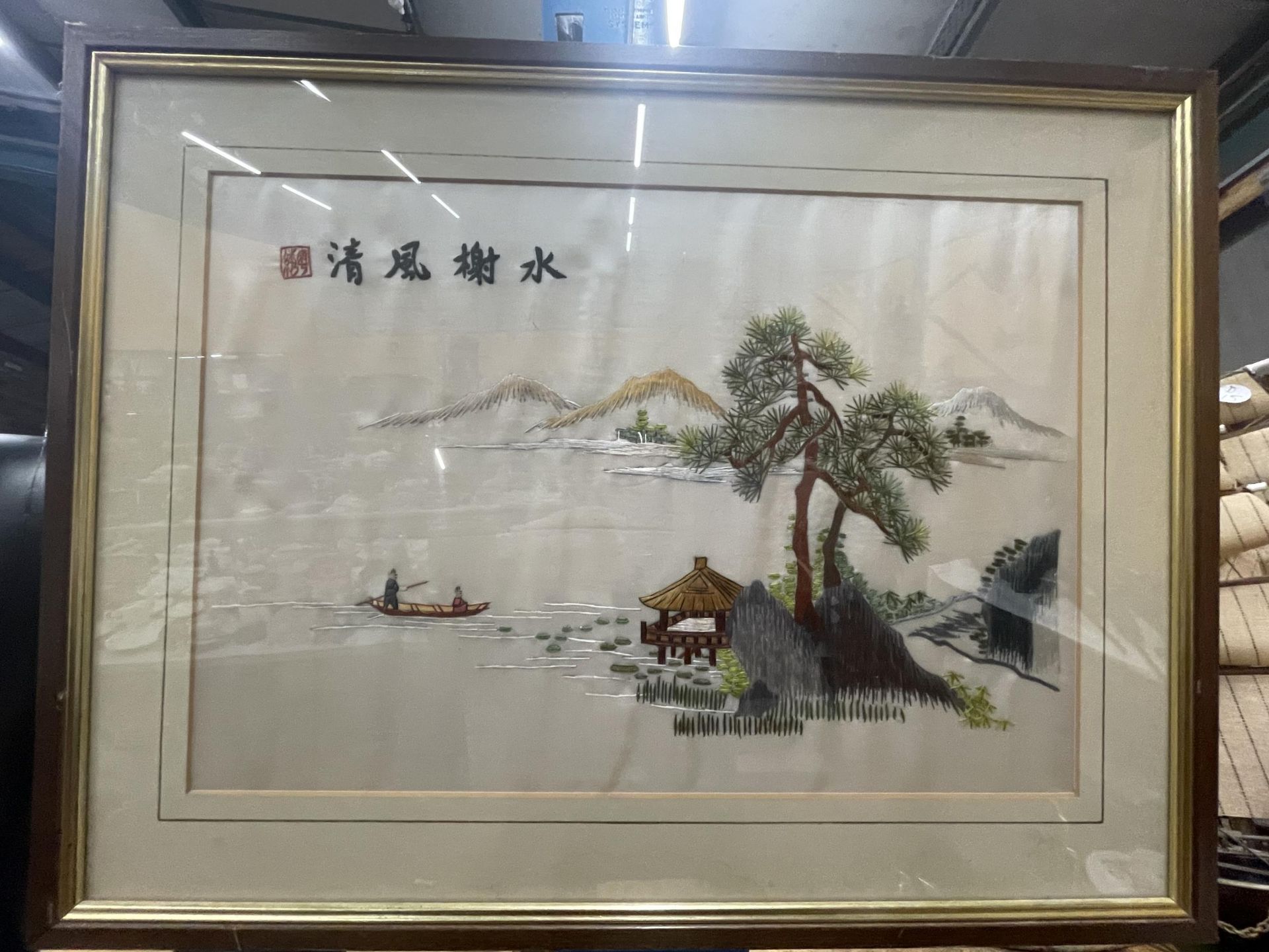 A FRAMED SILK EMBROIDERY OF AN ORIENTAL SCENE