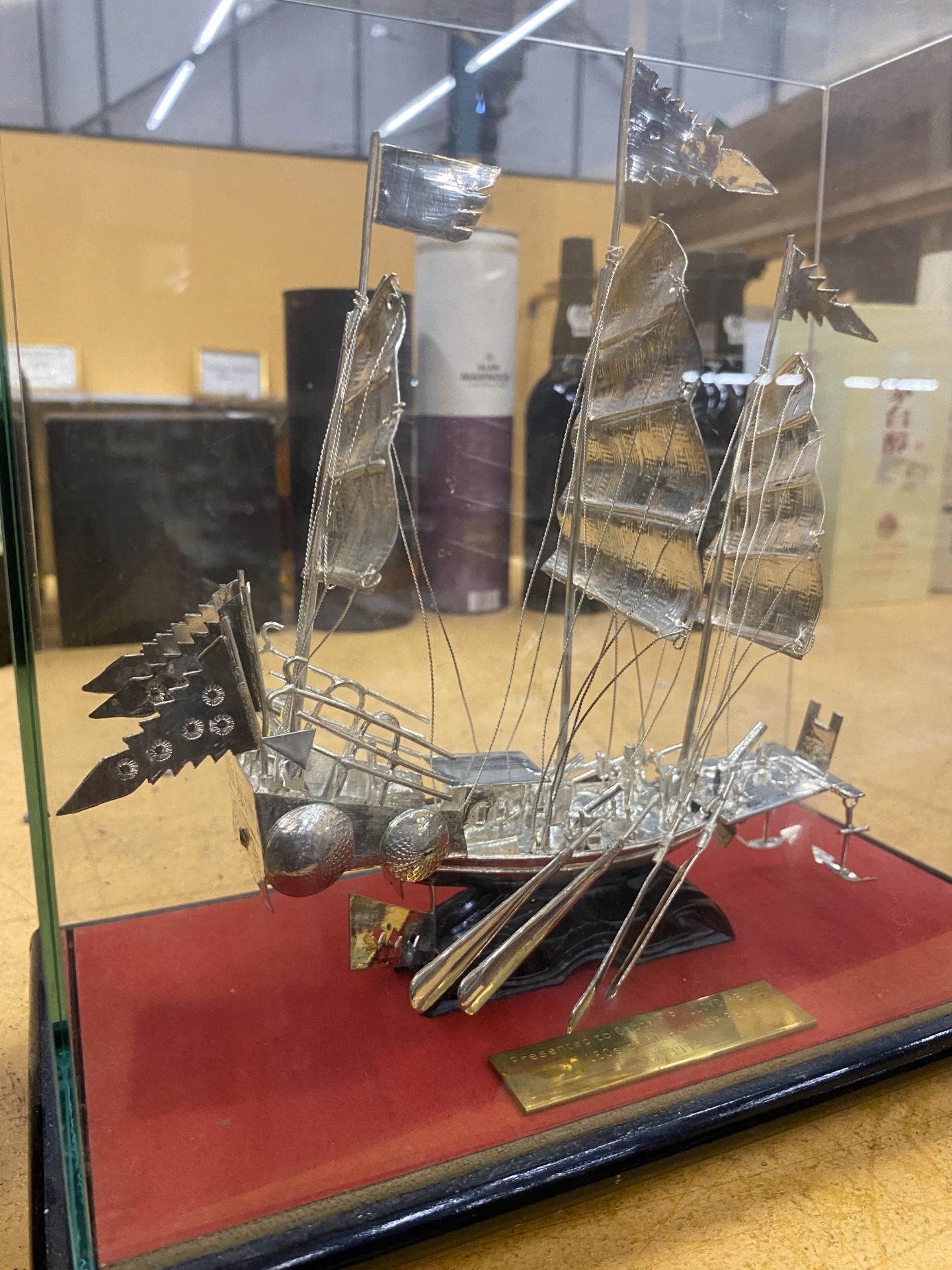 A PRESENTATION SILVER EFFECT WHITE METAL MODEL OF A BOAT IN A GLASS DISPLAY CASE - Image 2 of 3