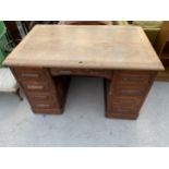 AN EARLY 20TH CENTURY OAK TWIN-PEDESTAL DESK ENCLOSING NINE DRAWER AND TWO SLIDES, 50X32"