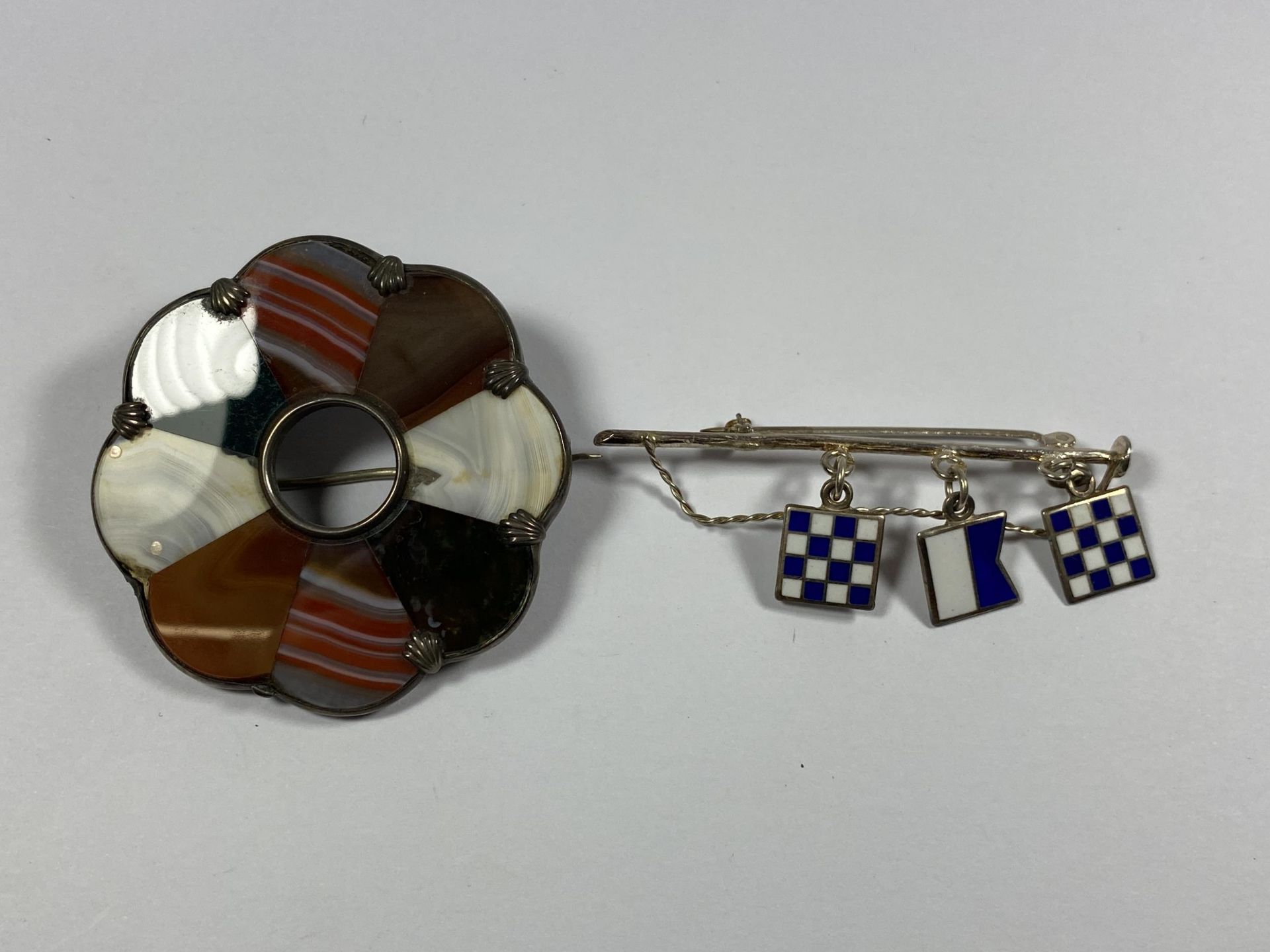 TWO VINTAGE BROOCHES TO INCLUDE A HALLMARKED SILVER AND ENAMEL FLAG EXAMPLE