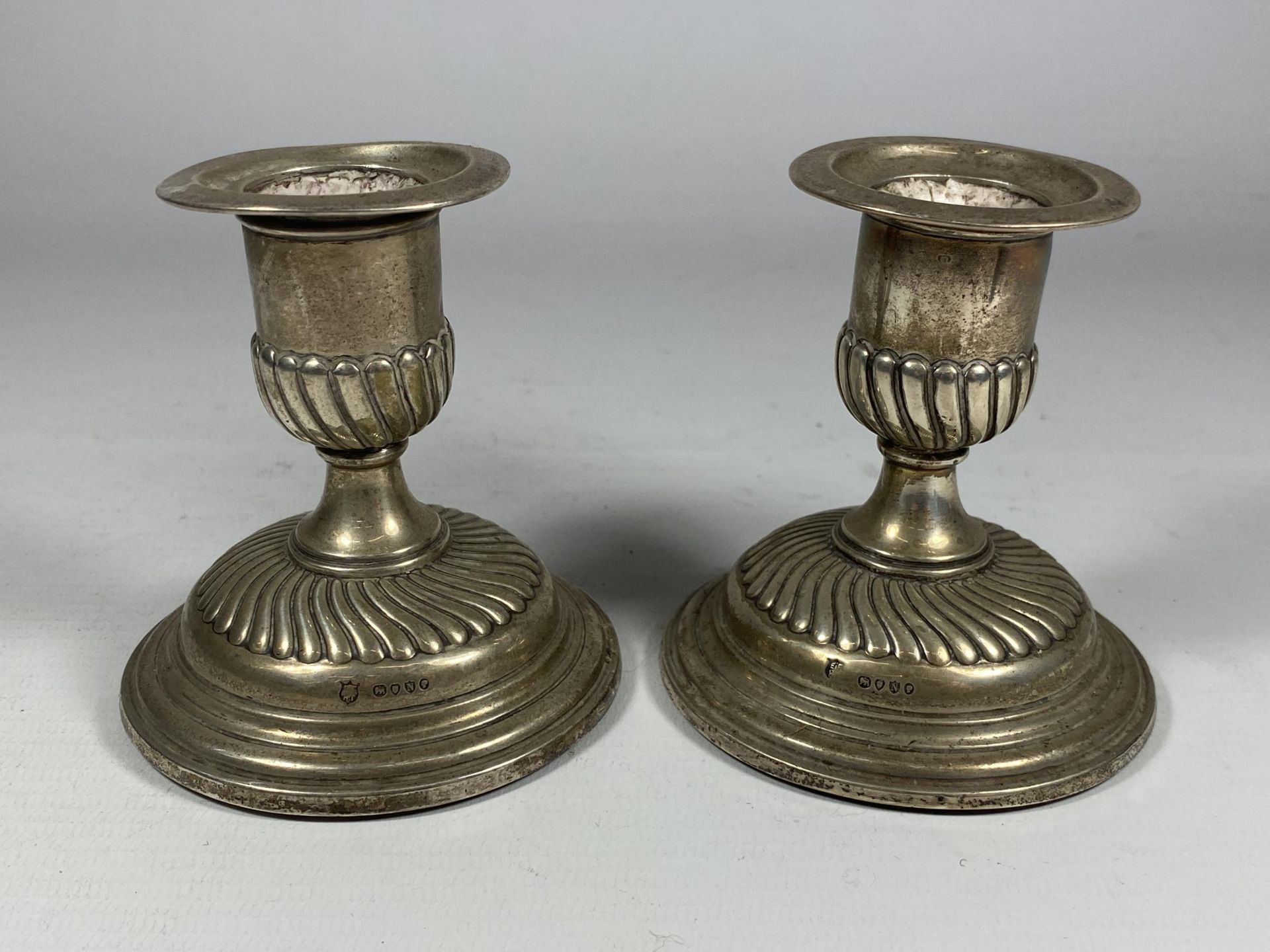 A PAIR OF VICTORIAN HALLMARKED SILVER CANDLESTICKS WITH FLUTED BASE DESIGN, HEIGHT 9CM