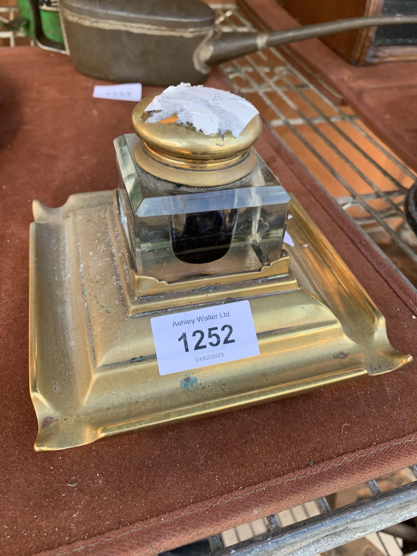 A VINTAGE BRASS AND GLASS DESK INK WELL