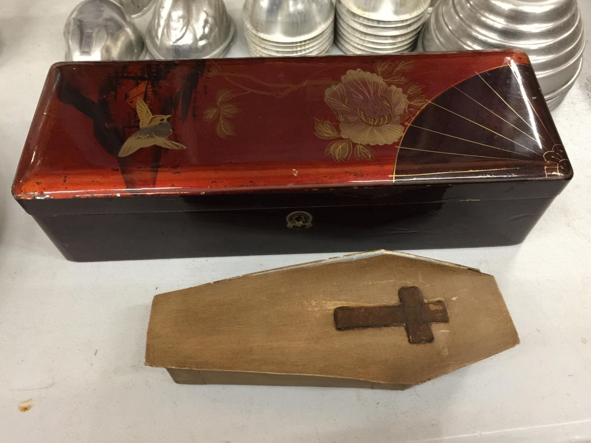 AN ORIENTAL STYLE LACQUERED GLOVE BOX PLUS A VOODOO FERTILITY DOLL IN A COFFIN