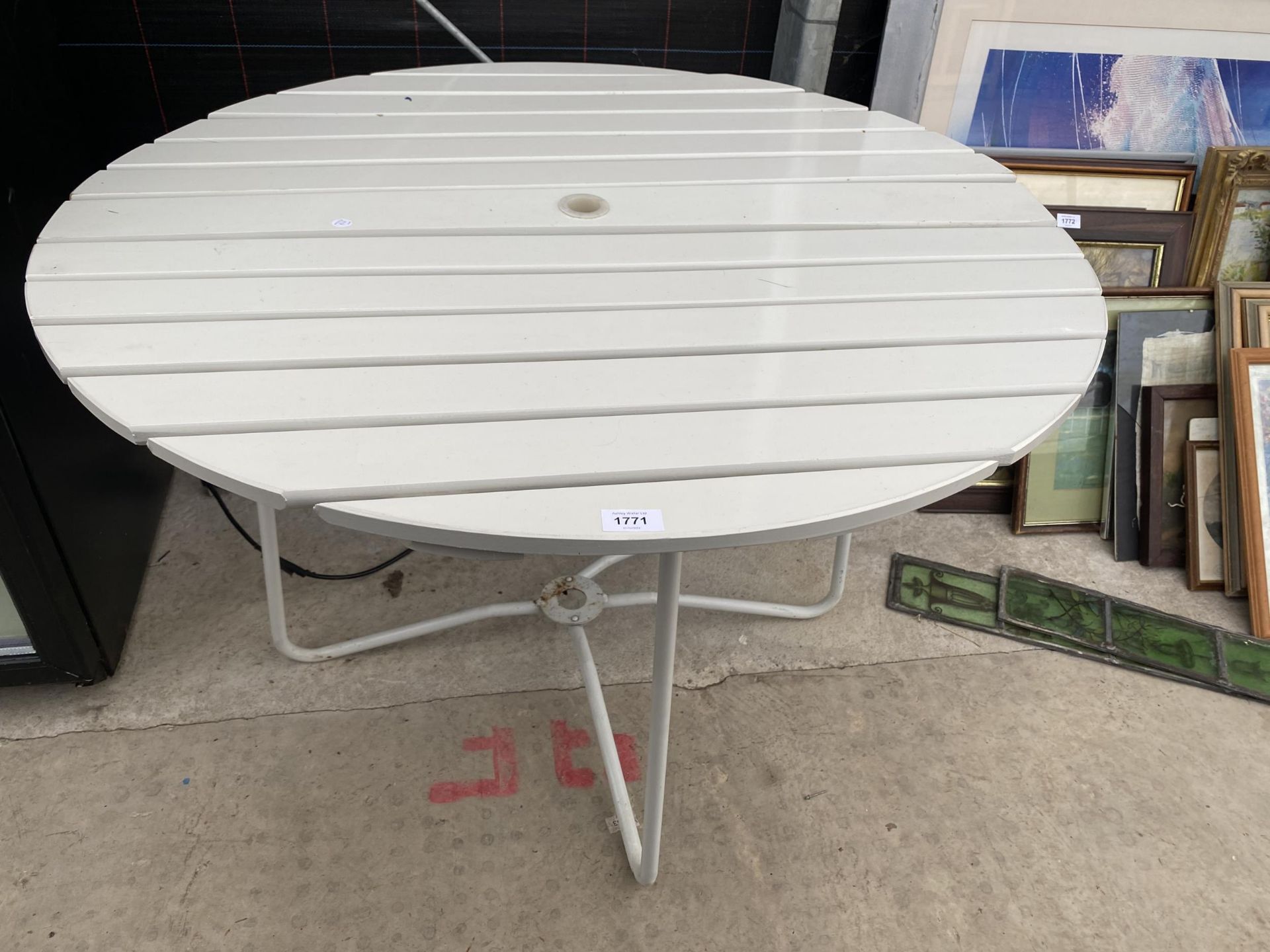 A ROUND WOODEN SLATTED TABLE