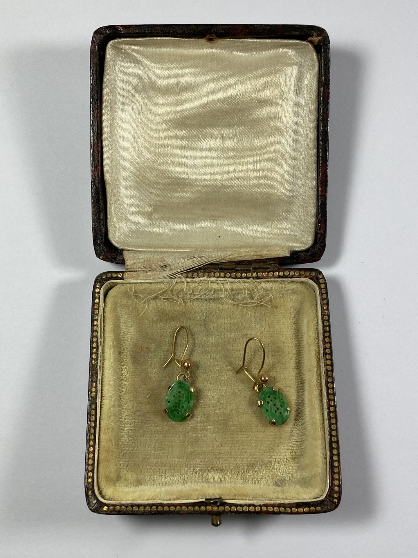 A CASED PAIR OF VINTAGE YELLOW METAL AND CARVED JADE TYPE EARRINGS