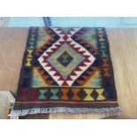 A SMALL PATERNED FRINGED RUG