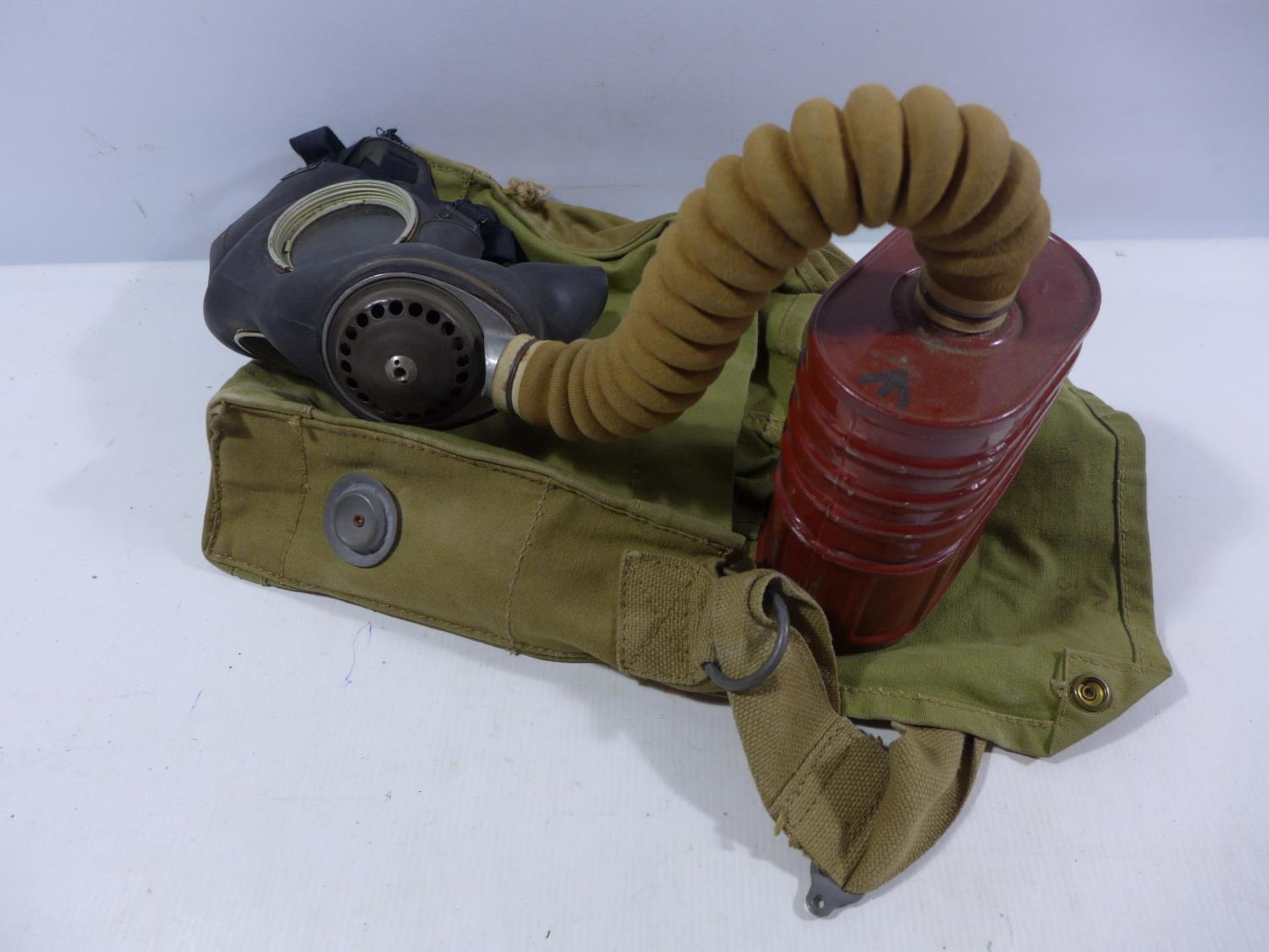 A WORLD WAR II MILITARY ISSUE GAS MASK AND BAG