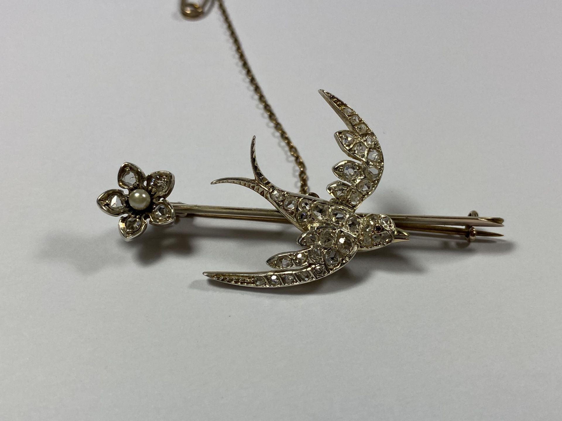 A BIRD AND FLORAL DIAMOND AND PEARL BROOCH SET WITH FORTY TWO MIXED CUT DIAMONDS, COLOUR G-H,