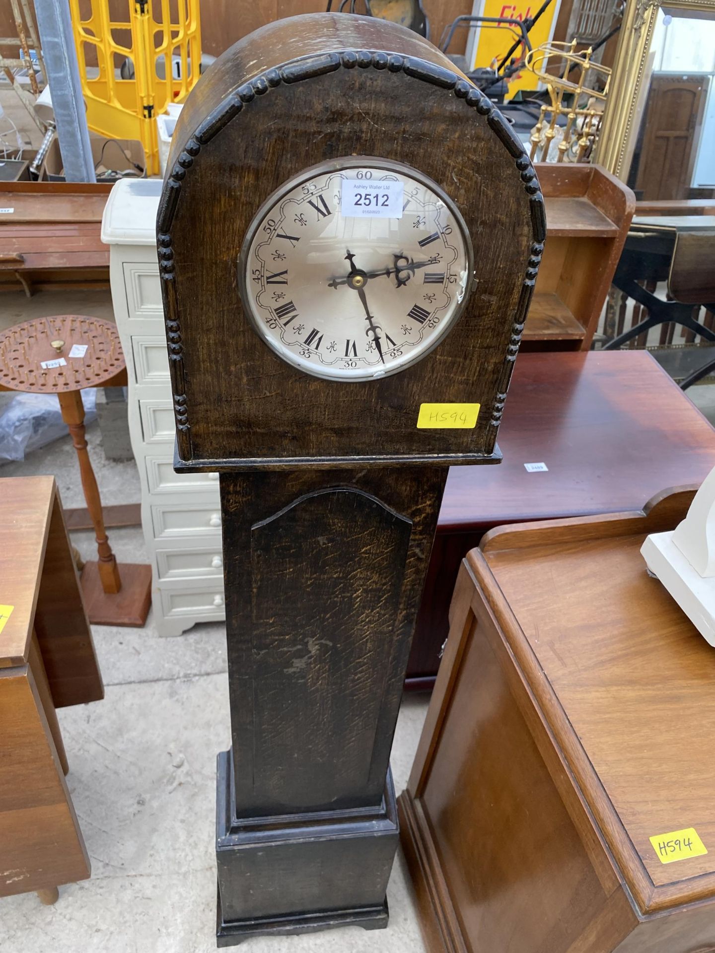 AN OAK GRANDMOTHER CLOCK WITH QUARTZ MOVEMENT