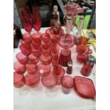 A LARGE QUANTITY OF CRANBERRY GLASS TO INCLUDE DRINKING GLASSES, VASES, JUGS, DECANTER, ETC.,