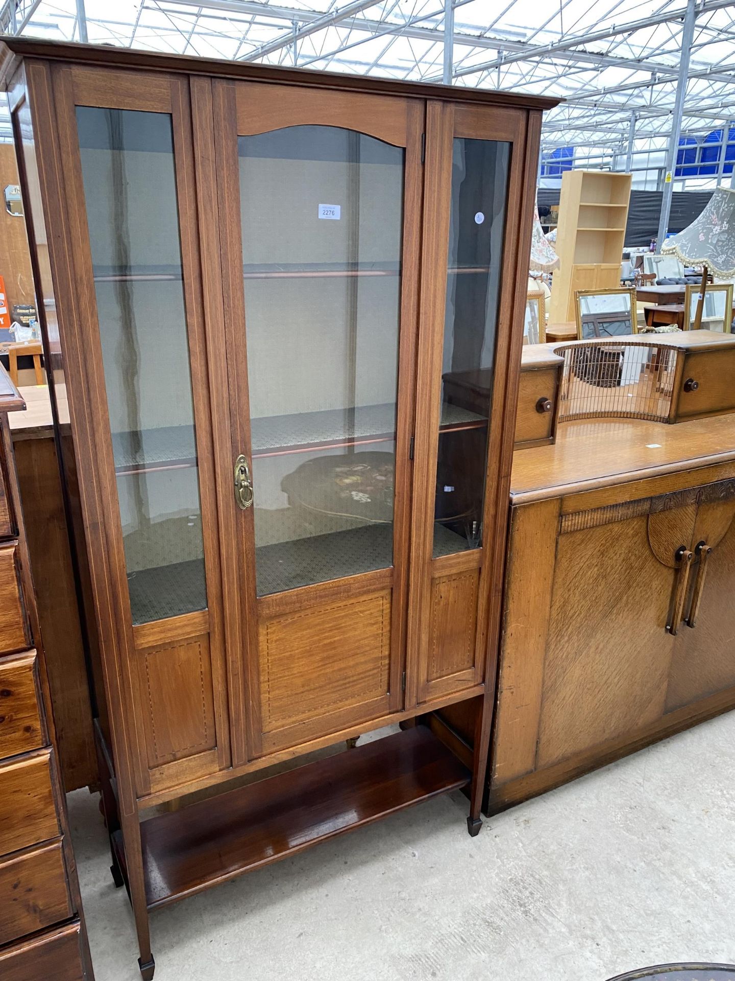 AN EDWARDIAN MAHOGANY AND INLAID DISPLAY CABINET ON OPEN BASE WITH SHELF, TAPERED LEGS AND SPADE