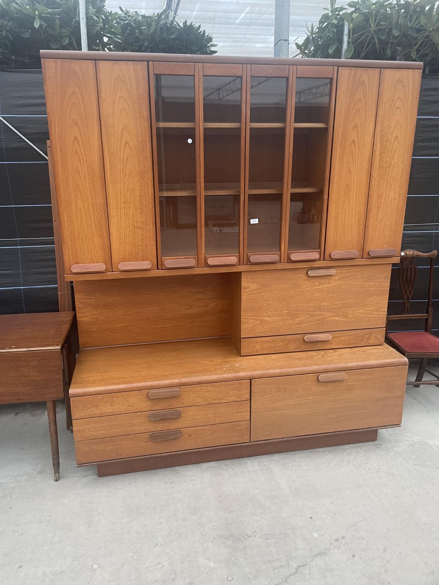 A RETRO TEAK COCKTAIL SIDEBOARD WITH FOUR BI-FOLD DOORS, TWO BEING GLAZED, DROP-DOWN COCKTAIL