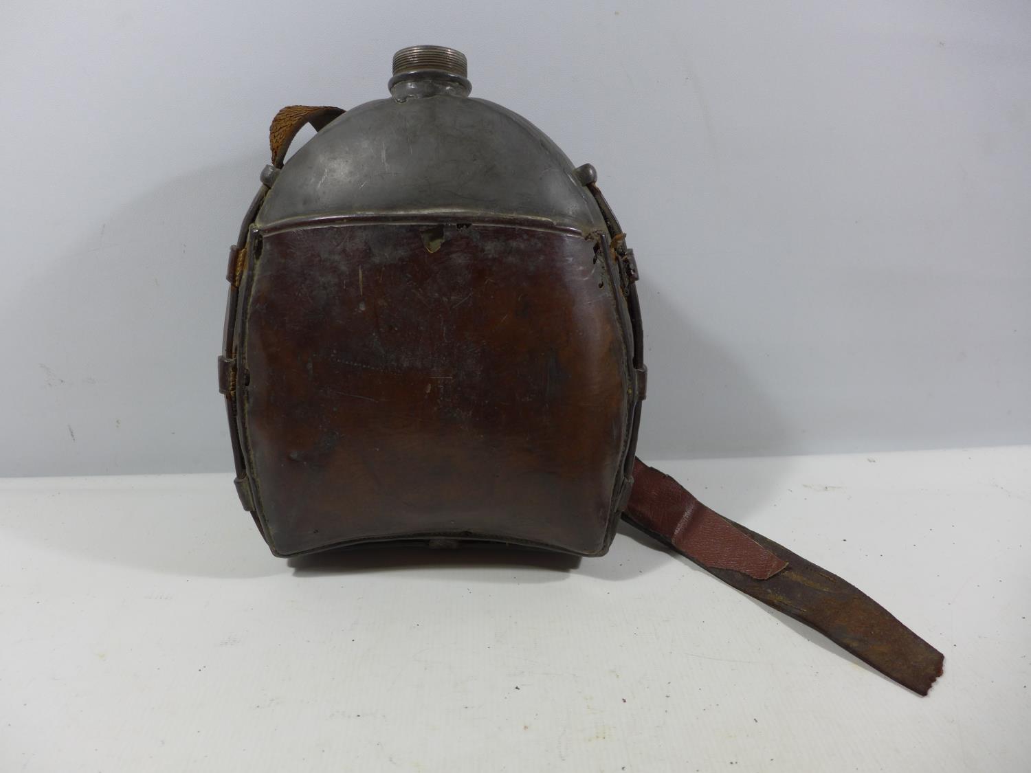 A LARGE WORLD WAR II BRITISH ARMY FAR EASTERN WATER BOTTLE WITH LEATHER STRAP