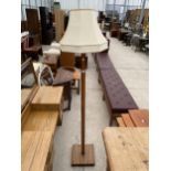 A MID 20TH CENTURY OAK STANDARD LAMP ON SQUARE SLATTED BLOCK BASE COMPLETE WITH SHADE