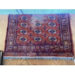 A RED PATTERNED FRINGED RUG