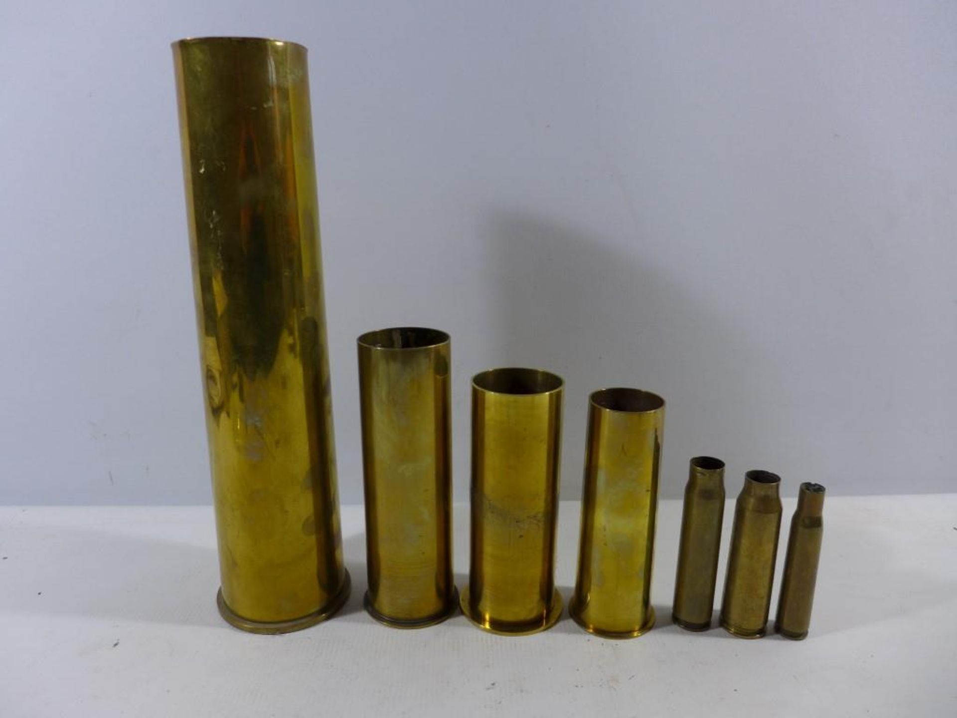 A COLLECTION OF SEVEN SHELL CASES, HEIGHTS VARY FROM 10 TO 35CM