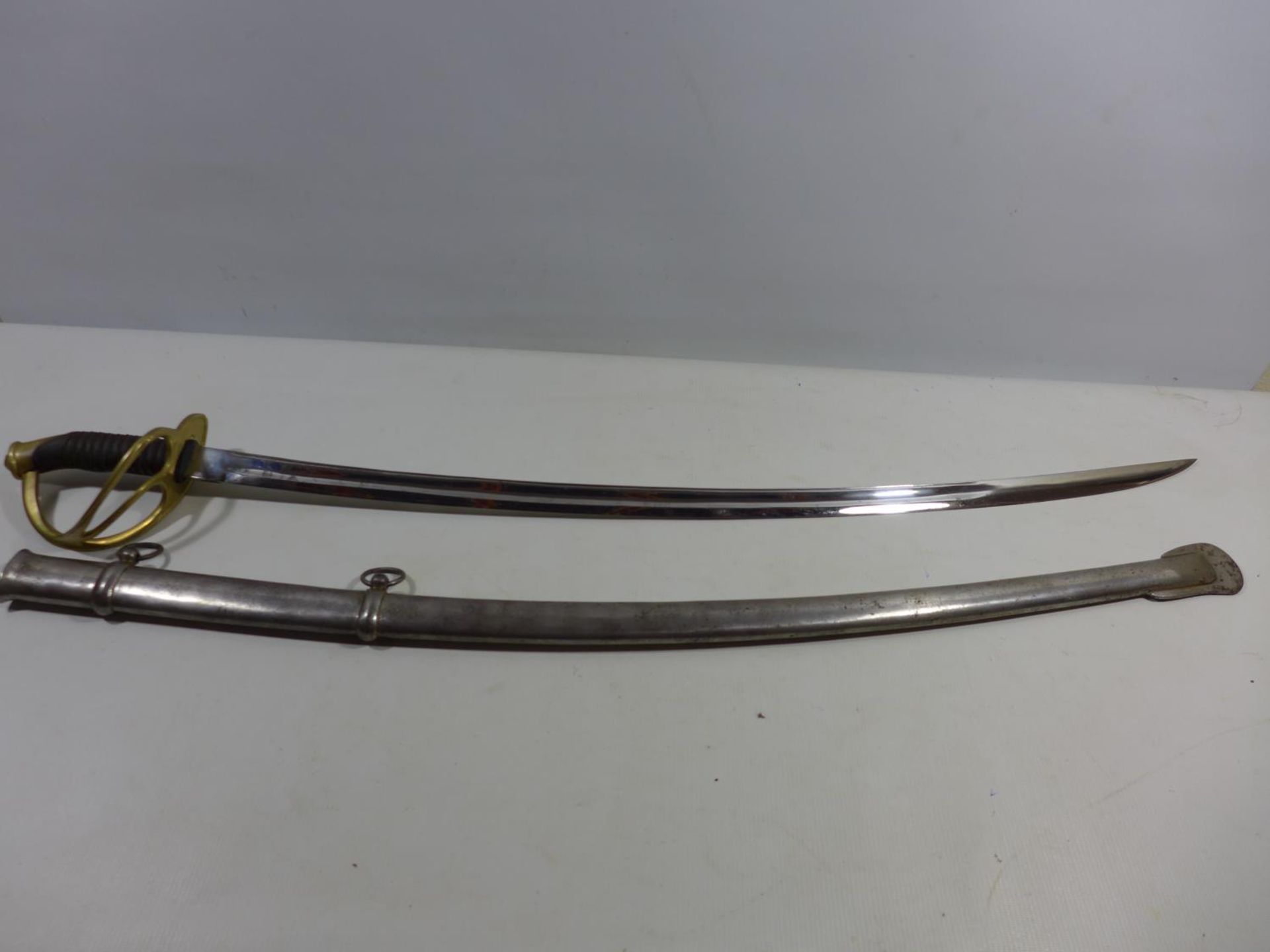 A CAVALRY SWORD AND SCABBARD OF UNKNOWN AGE, 87CM BLADE, PIERCED BRASS GUARD
