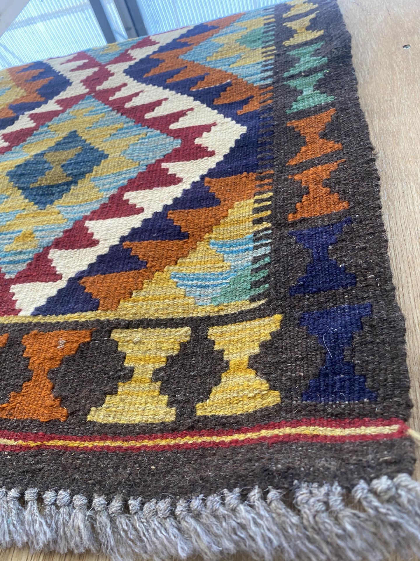 A SMALL PATERNED FRINGED RUG - Image 2 of 2