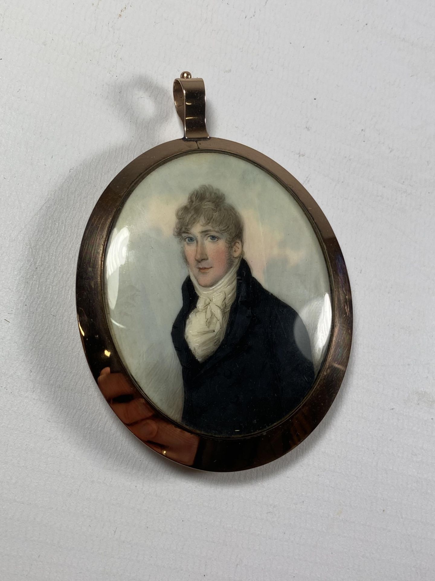 A 19TH CENTURY OVAL PORTRAIT MINIATURE OF A GENTLEMAN IN BELIEVED GOLD FRAME