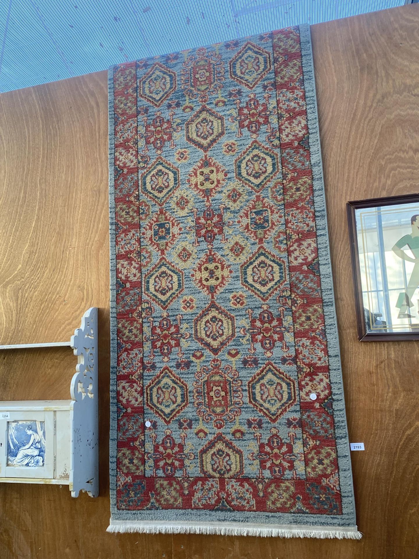 A LARGE NARROW BLUE AND RED PATTERNED HALL RUNNER