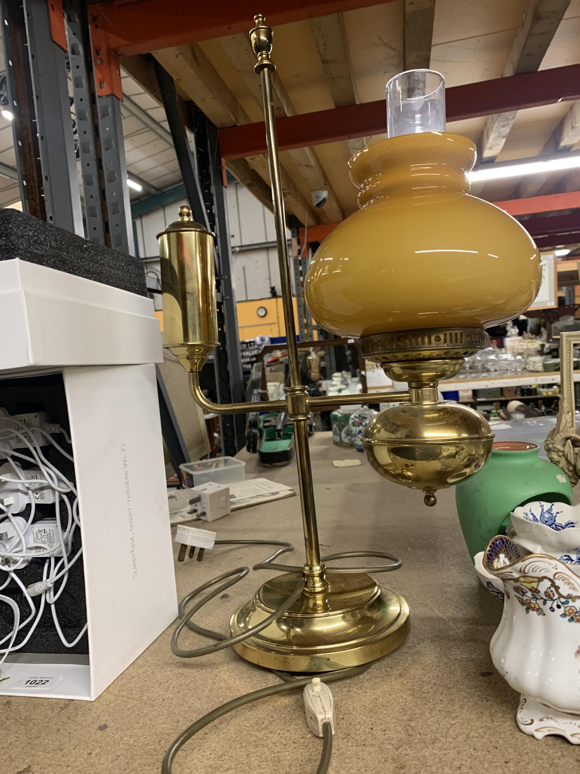 A HEAVY BRASS VINTAGE STYLE LAMP WITH MUSTARD GLASS SHADE AND CLEAR CHIMNEY HEIGHT APPROX 56CM