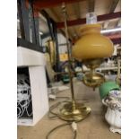 A HEAVY BRASS VINTAGE STYLE LAMP WITH MUSTARD GLASS SHADE AND CLEAR CHIMNEY HEIGHT APPROX 56CM
