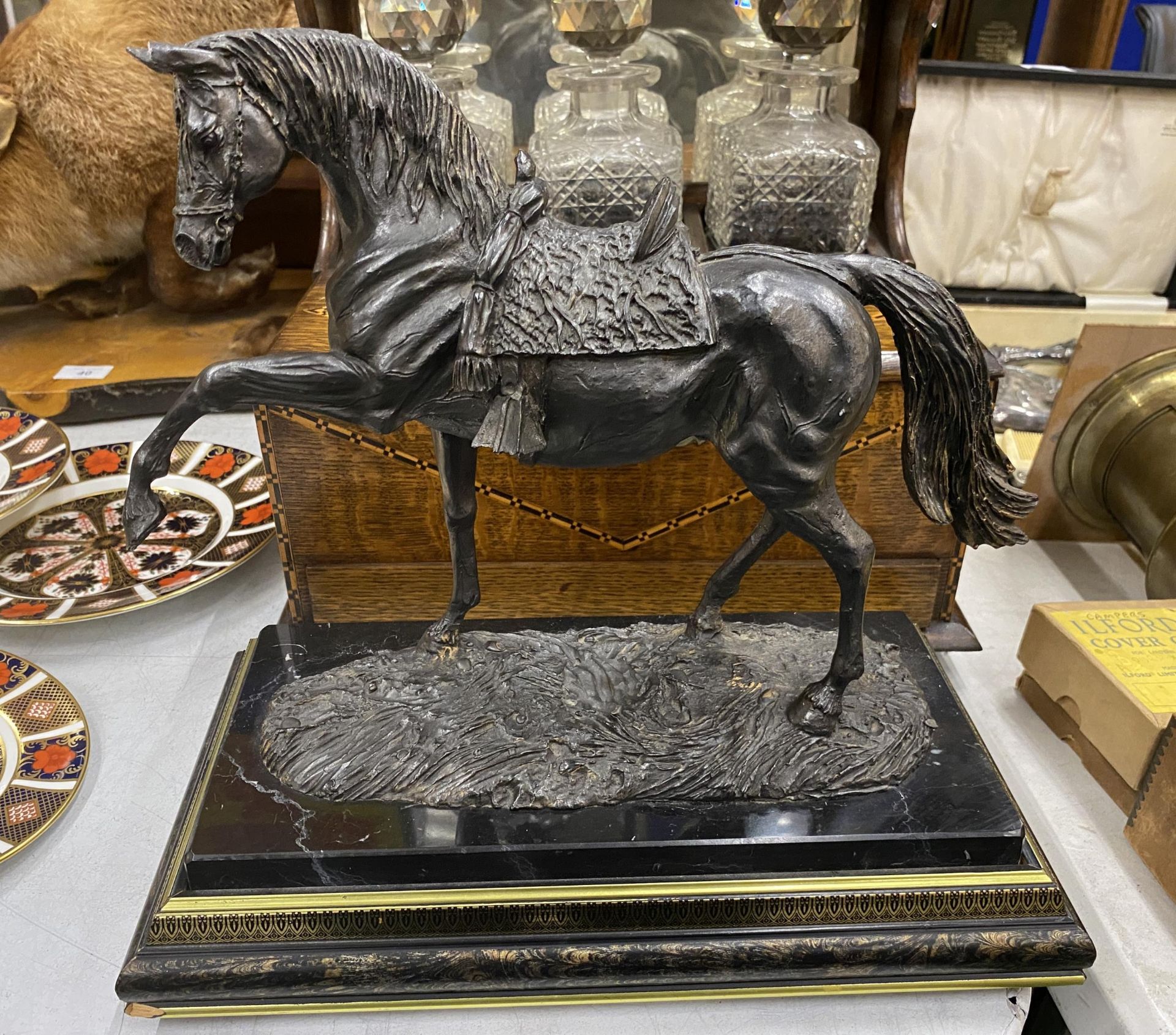 A BRONZE EFFECT RESIN MODEL OF A RACE HORSE ON WOODEN AND BLACK MARBLE BASE, LENGTH 31CM