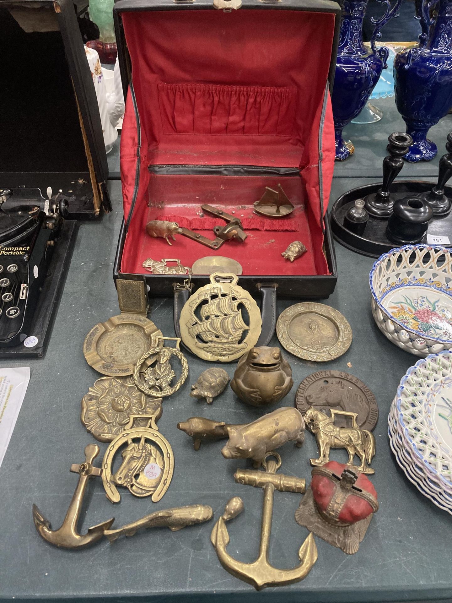 A GLADSTONE STYLE BAG CONTAINING A QUANTITY OF BRASS ITEMS TO INCLUDE A CORONATION CROWN MONEY