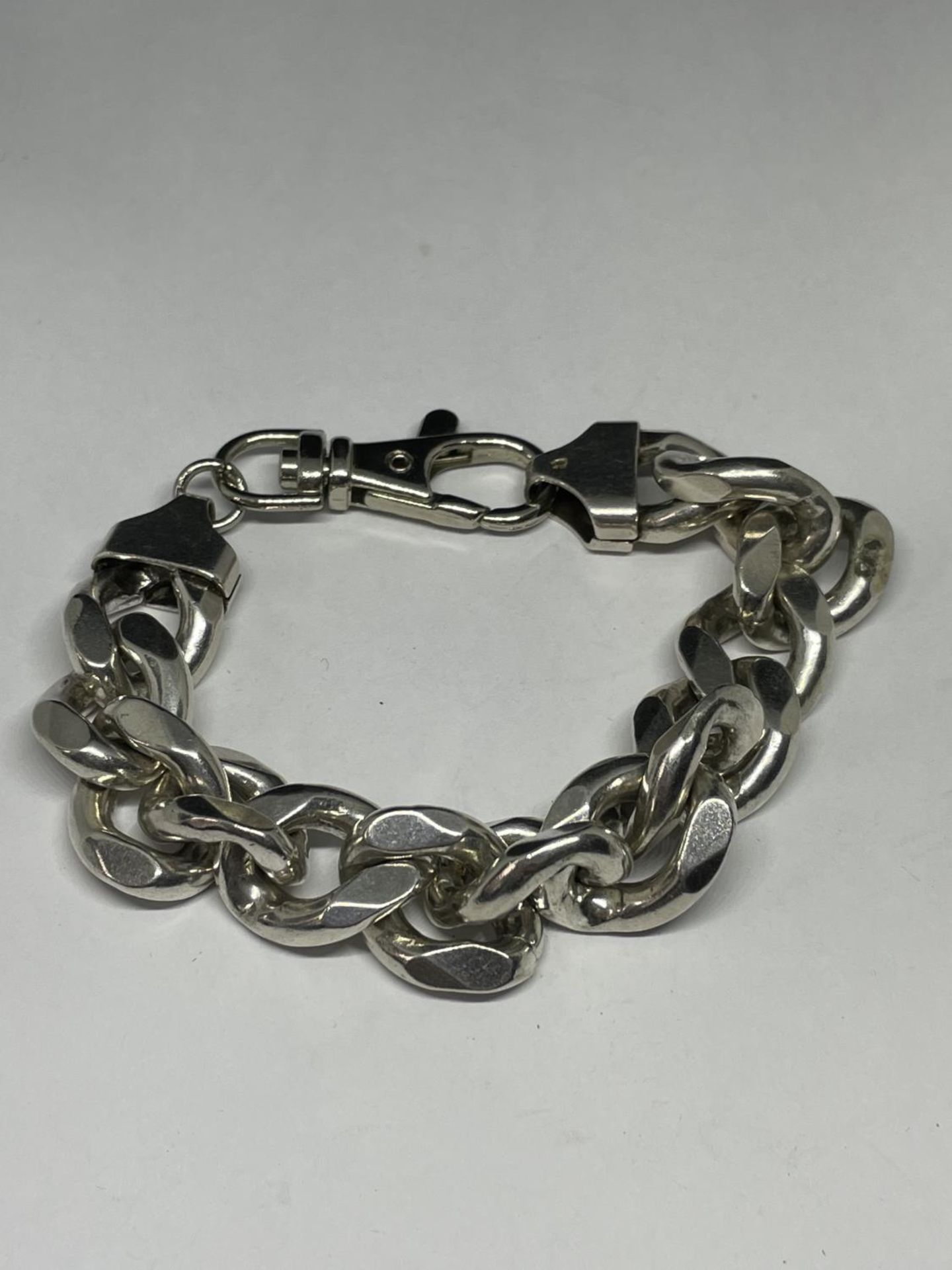 A HEAVY SILVER WRIST CHAIN WITH METAL CLASP