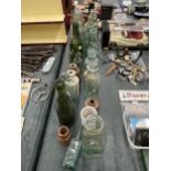 A LARGE QUANTITY OF VINTAGE GLASS BOTTLES TO INCLUDE ADVERTISING ONES