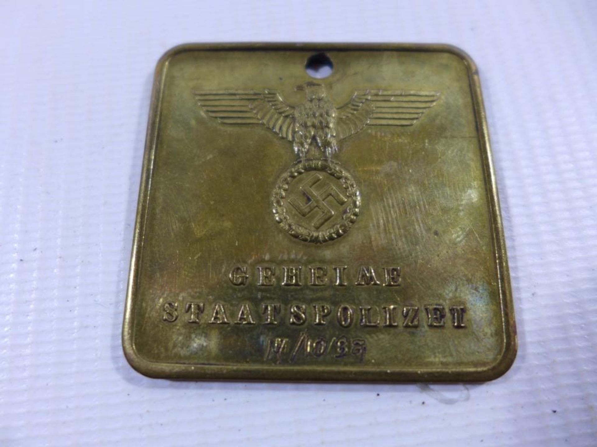 A BRASS PLAQUE DECORATED WITH A NAZI GERMANY EAGLE AND INSCRIPTON GEHEIME STAATSPOLIZEI, VERSO