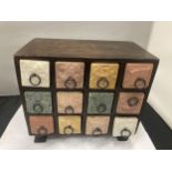 A SMALL WOODEN CHEST WITH TWELVE CERAMIC DRAWERS WIDTH 25.5CM, HEIGHT 23CM, DEPTH 14CM