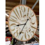 A LARGE OVAL WALL CLOCK 60CM X 50CM