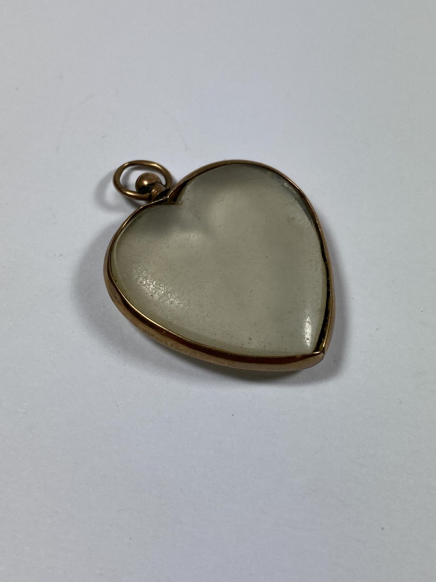 A VINTAGE 9CT YELLOW GOLD & CLEAR GLASS CASED HEART PENDANT