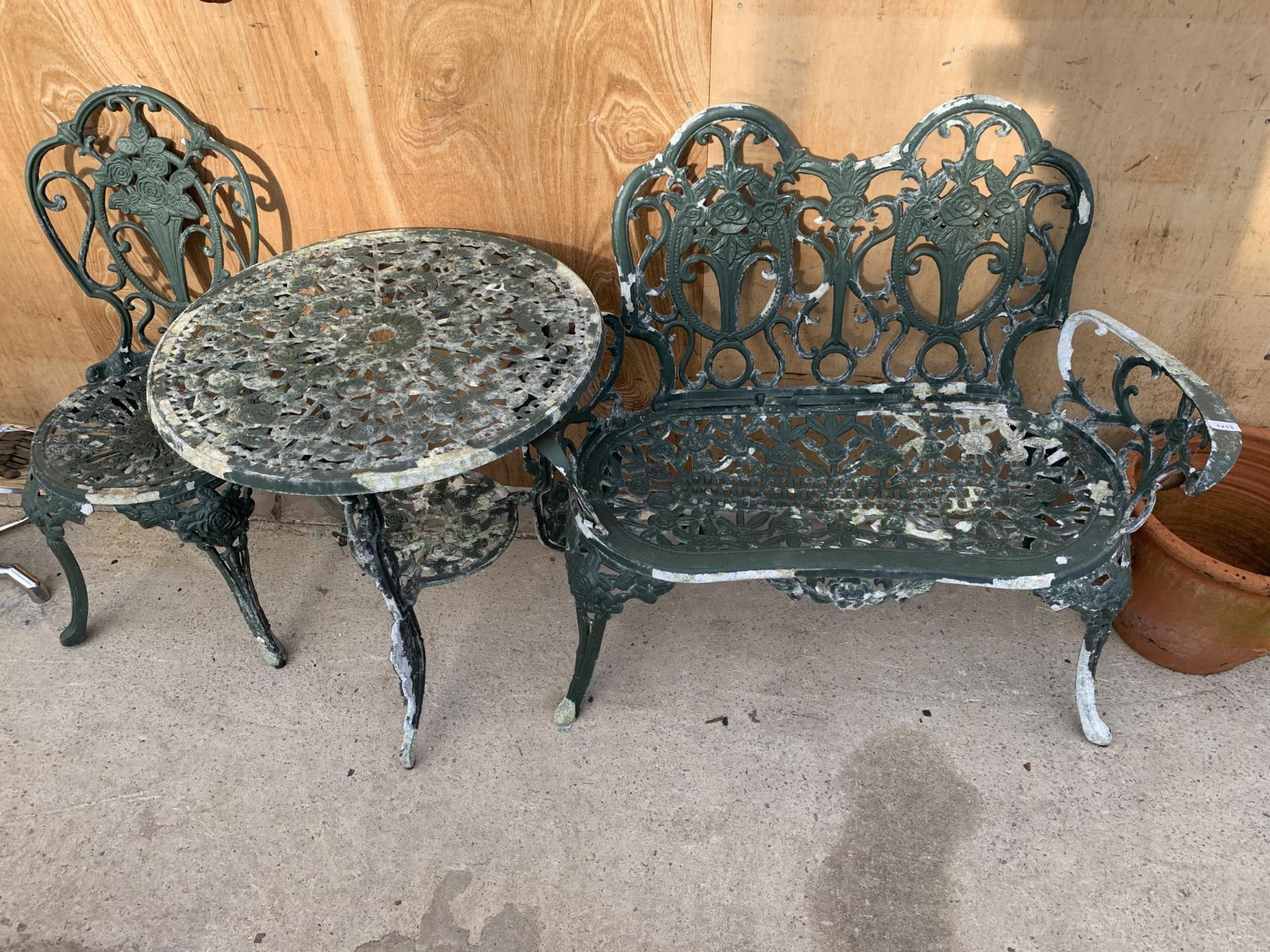 A VINTAGE CAST ALLOY BISTRO SET COMPRISING OF A ROUND TABLE, A BENCH AND A SINGLE CHAIR