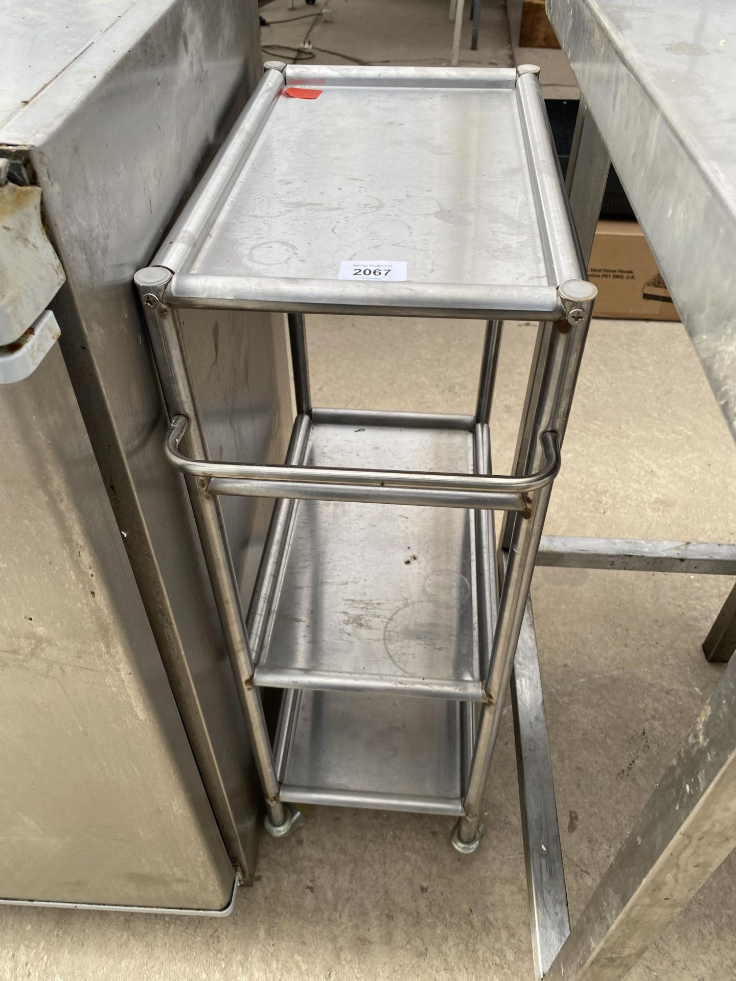 A SMALL THREE TIER STAINLESS STEEL TROLLEY