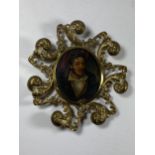 AN ORNATE BRASS FRAMED BYRONESQUE OIL PORTRAIT MINIATURE, LENGTH 14CM