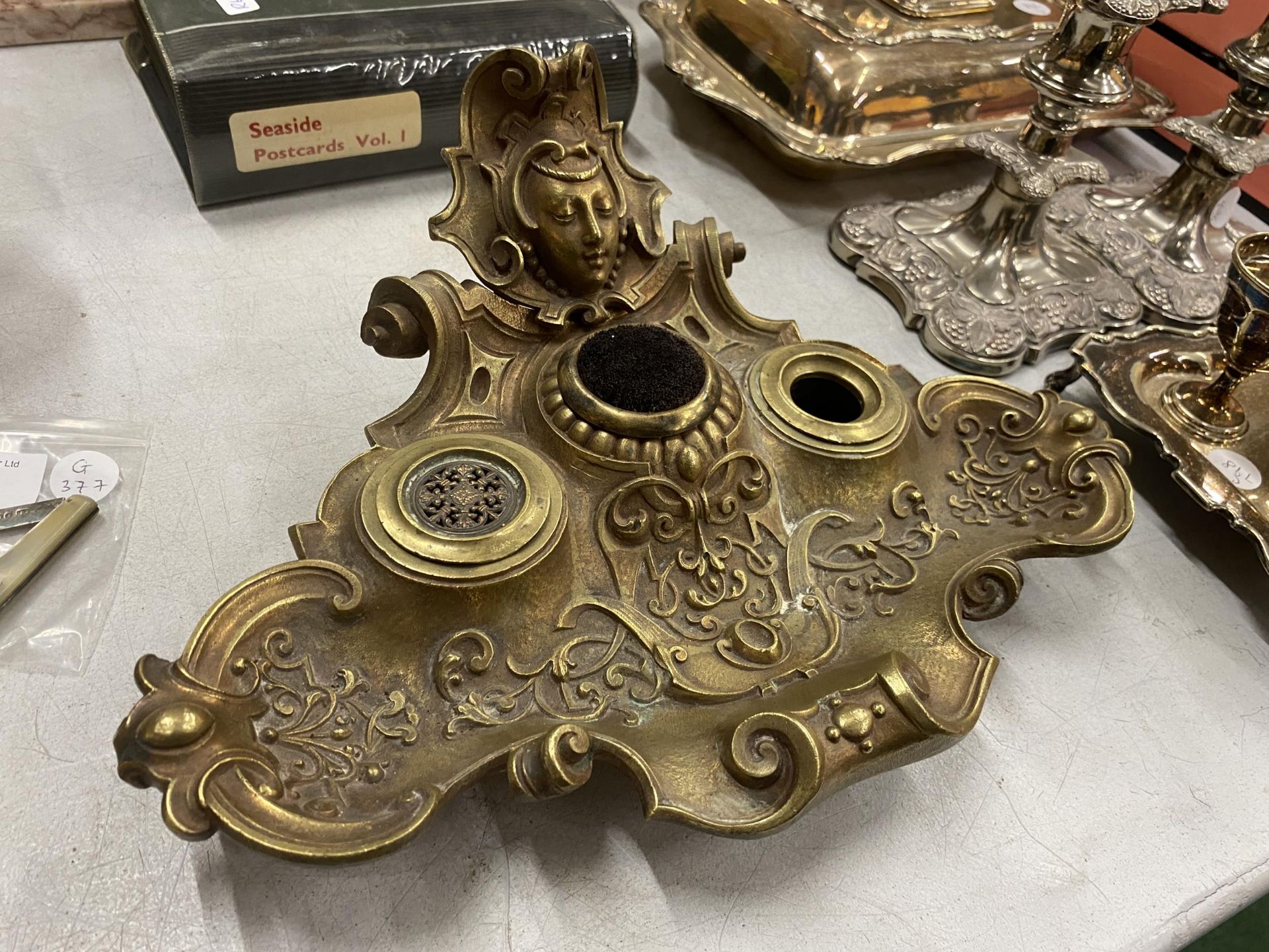 AN ART NOUVEAU BRASS INKSTAND WITH LADIES HEAD DESIGN TOP