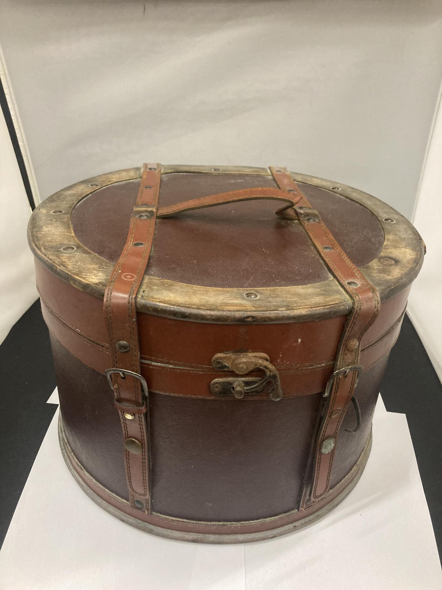 A ROUND LEATHER AND BRASS BOX - POSSIBLY A HAT BOX